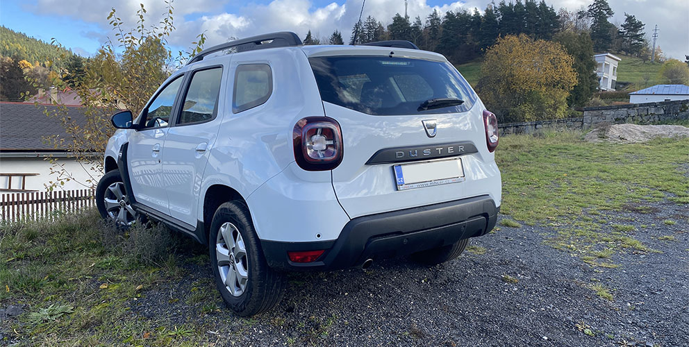 Bílá Dacia Duster - pohled šikmo zezadu