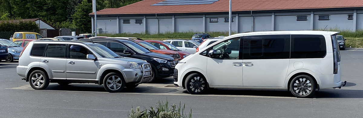 Hyundai Staria zaparkovaná u Nissanu X-Trail